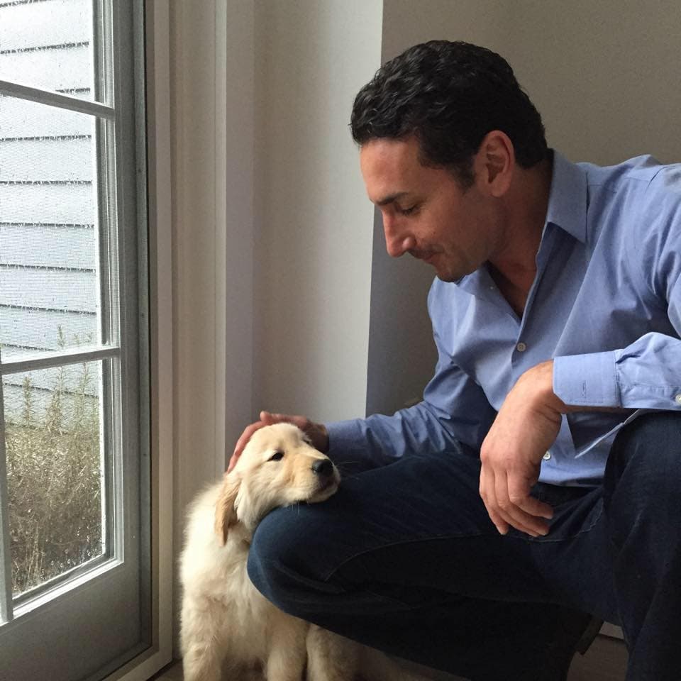 Michael Konstantaras with a golden retriever puppy